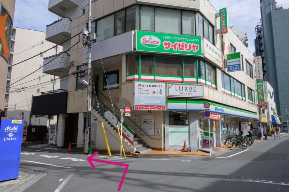 ファミリーマートとサイゼリヤが入る建物。手前を左に曲がる矢印